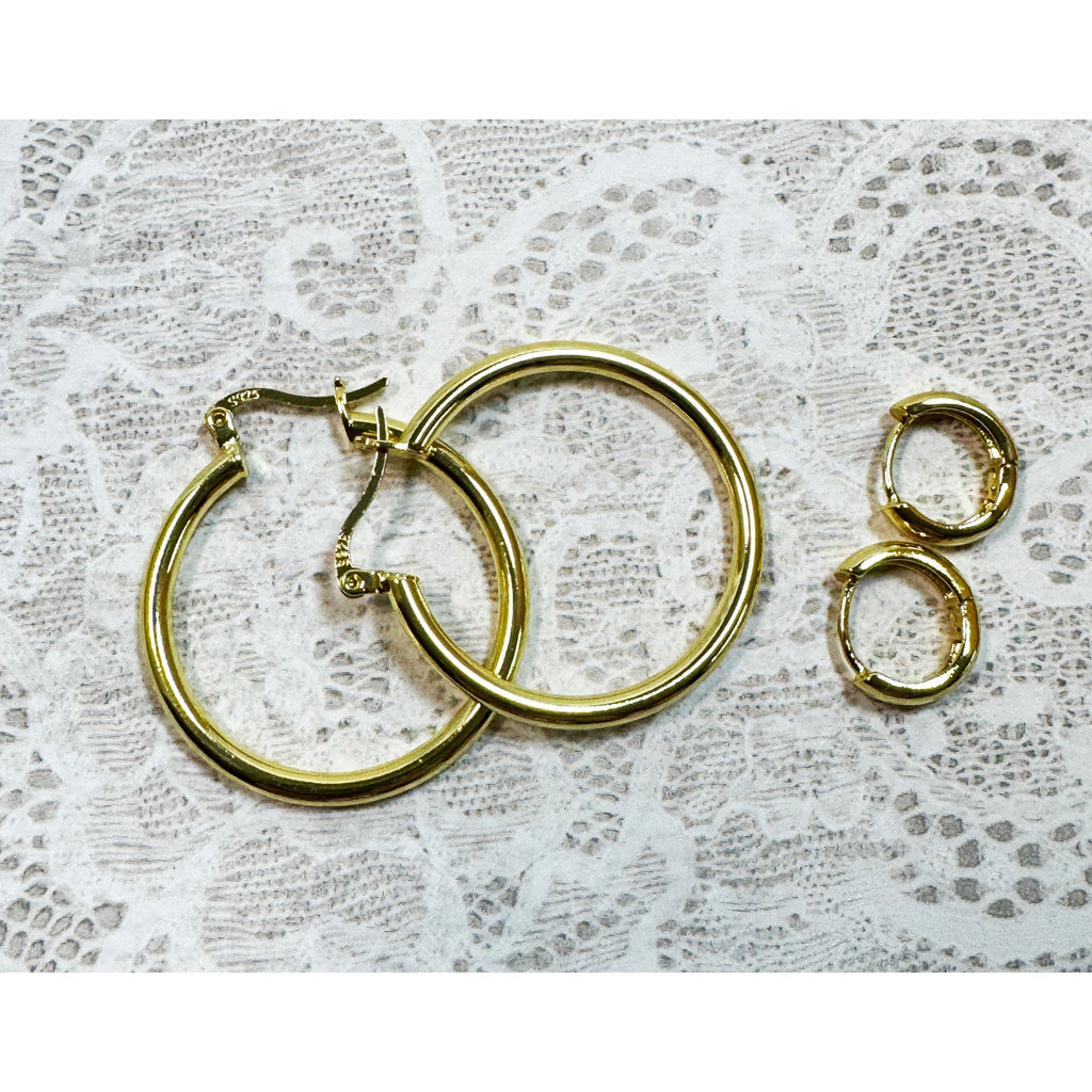A Pair of Gold Hoop Earrings  One 1 1/4 Inch and One Huggies 3/8 Inch E299