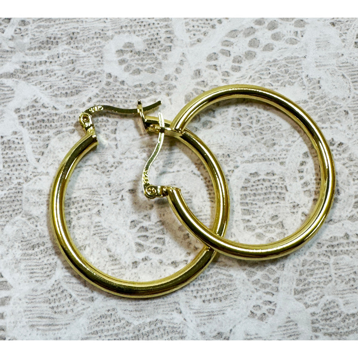 A Pair of Gold Hoop Earrings  One 1 1/4 Inch and One Huggies 3/8 Inch E299