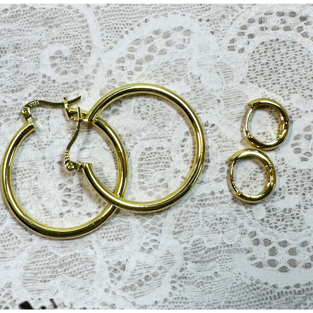 A Pair of Gold Hoop Earrings  One 1 1/4 Inch and One Huggies 3/8 Inch E299