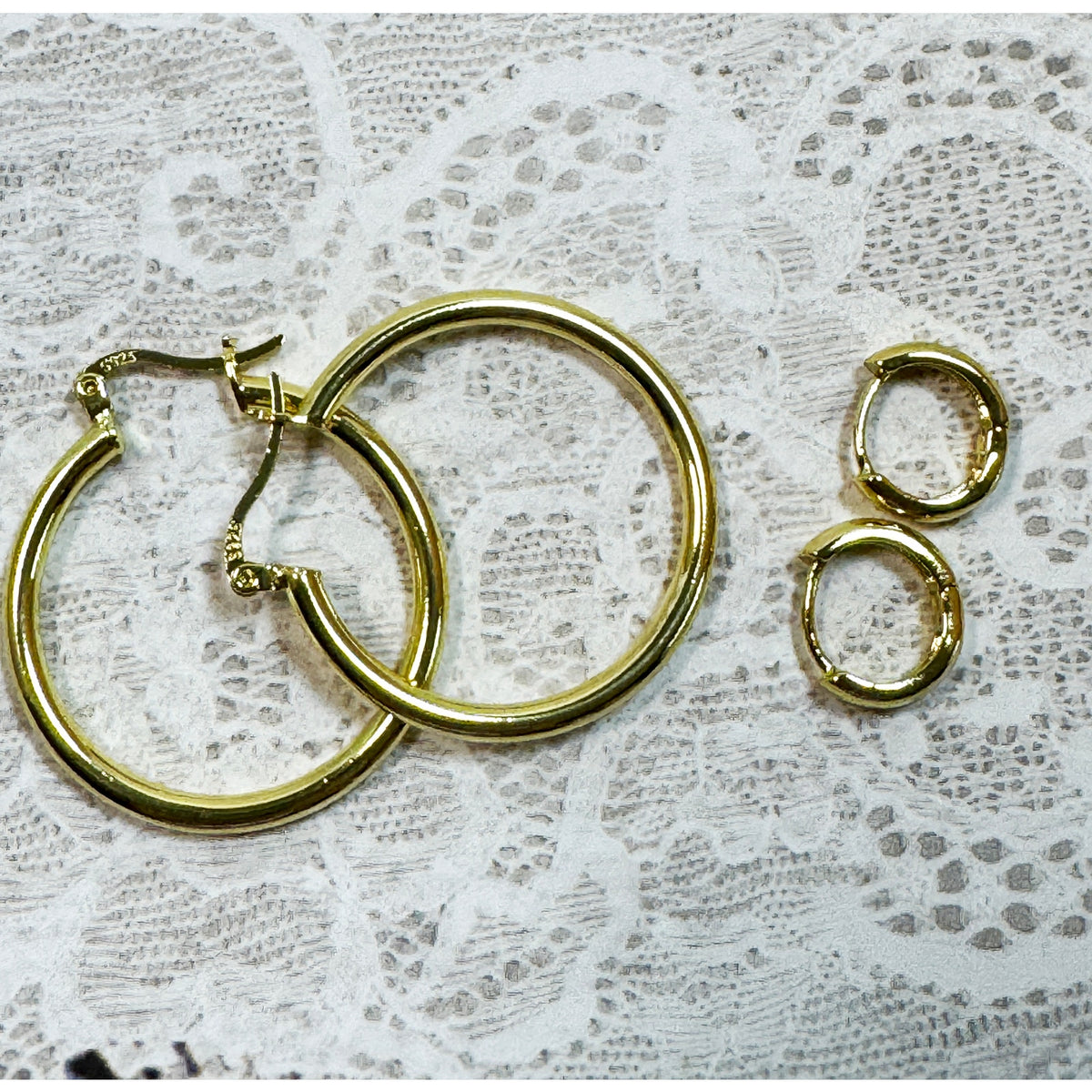 A Pair of Gold Hoop Earrings  One 1 1/4 Inch and One Huggies 3/8 Inch E299